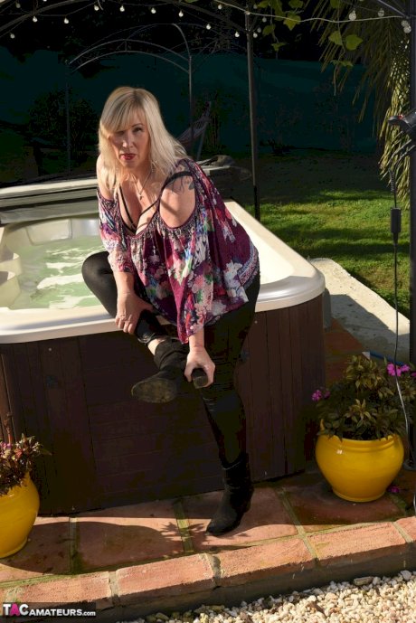 Fat older blonde Melody peels off black leggings afore an outdoor hot tub