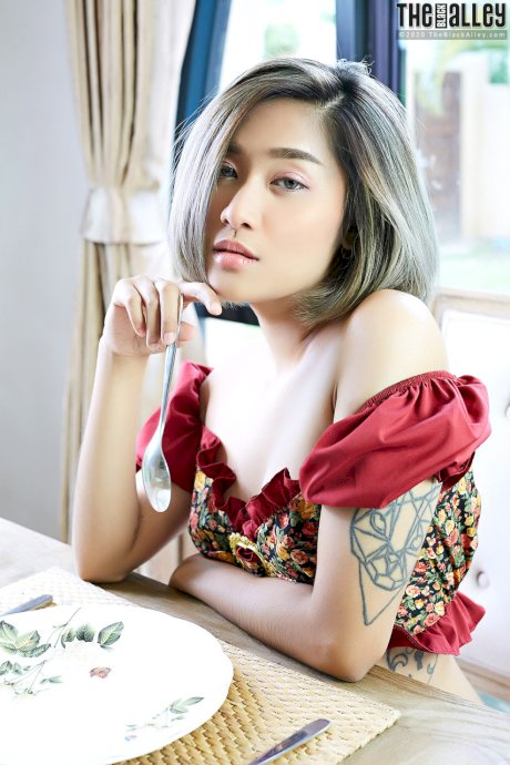 Asian solo girl Apple rubs her bush on a table after going topless