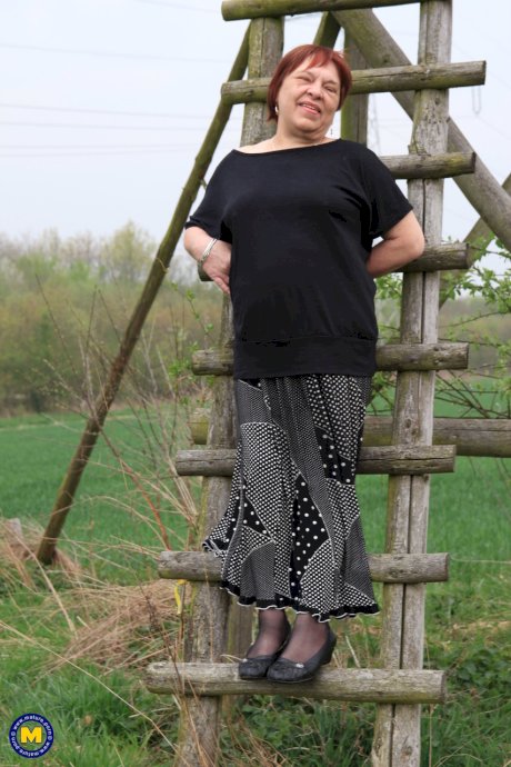 Redhead granny Sheila reveals her swollen vagina on an outdoor ladder