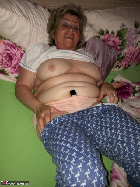 Horny older woman licks her nipple before dildoing her hairy pussy