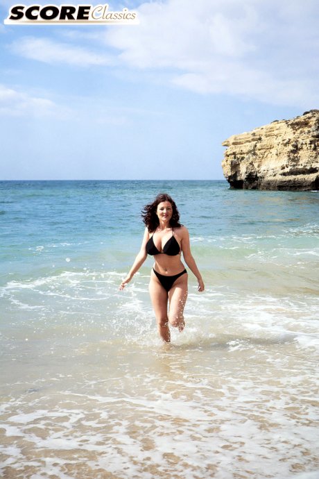 Brunette MILF Lorna Morgan releases her nice melons from bikini on a beach
