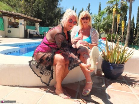 Mature blonde fatty Melody and her lesbian lover have foot play near a pool