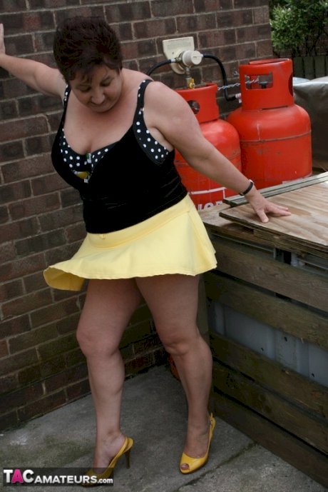Fat older woman Kinky Carol flashes her bra and upskirt underwear on a patio