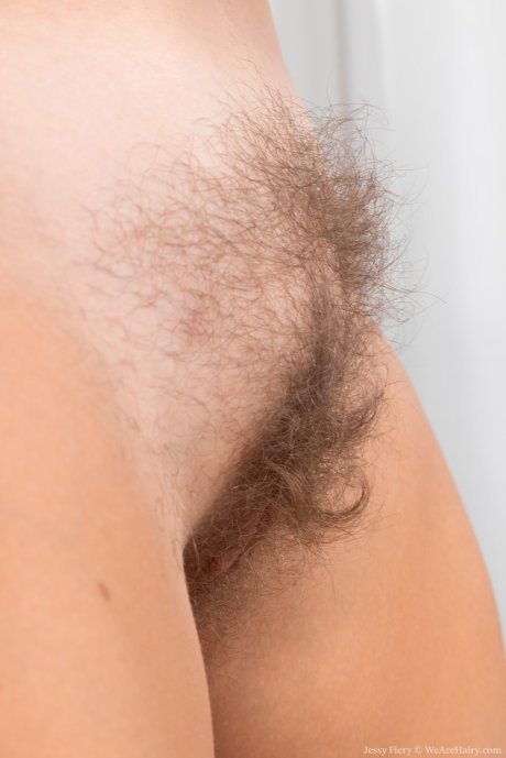Blonde amateur Jessy Fiery tugs on the labia lips of her hairy pussy