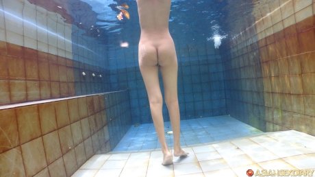 Cute Asian teen Adelia shows off her sexy body & gets in the pool while naked