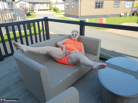 Fat nan bares her boobs while in a patio hot tub before getting naked on a bed