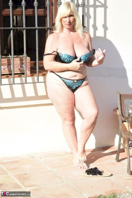 Older blonde Melody cradles her boobs after baring her overweight body