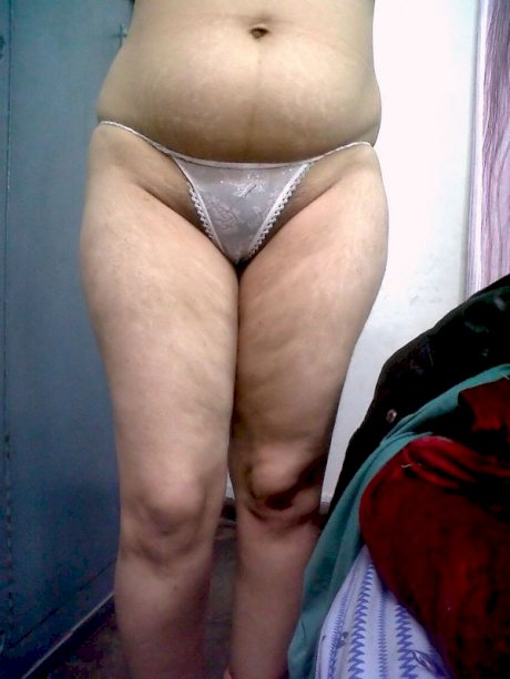 Fat Indian woman hides her face while adorned in a bra and thong