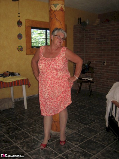 Fat granny Girdle Goddess holds her saggy tits in her hands by a pillar