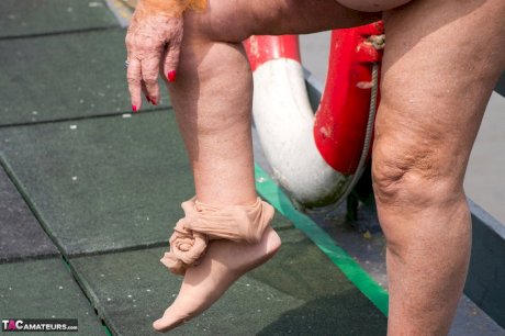 Obese oma Grandma Libby doffs a see-through raincoat to get naked on a bridge