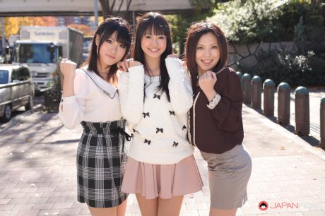 Three Japanese girls in skirts pose outdoors for a SFW shoot